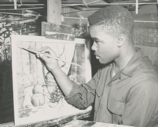 Young David C. Driskell in black and white painting a still life