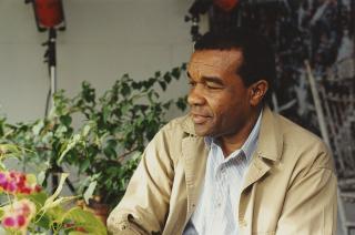 David C. Driskell in color surrounded by plants looking off to his right