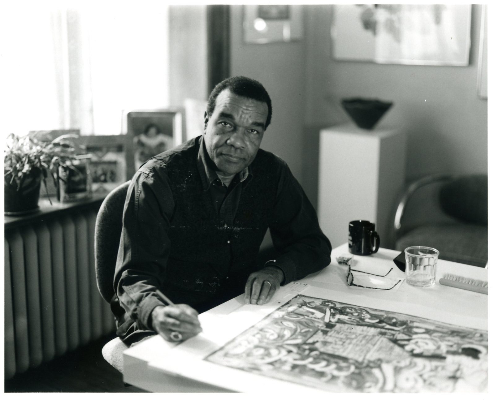 Professor David C. Driskell sitting in front of artwork in black and white