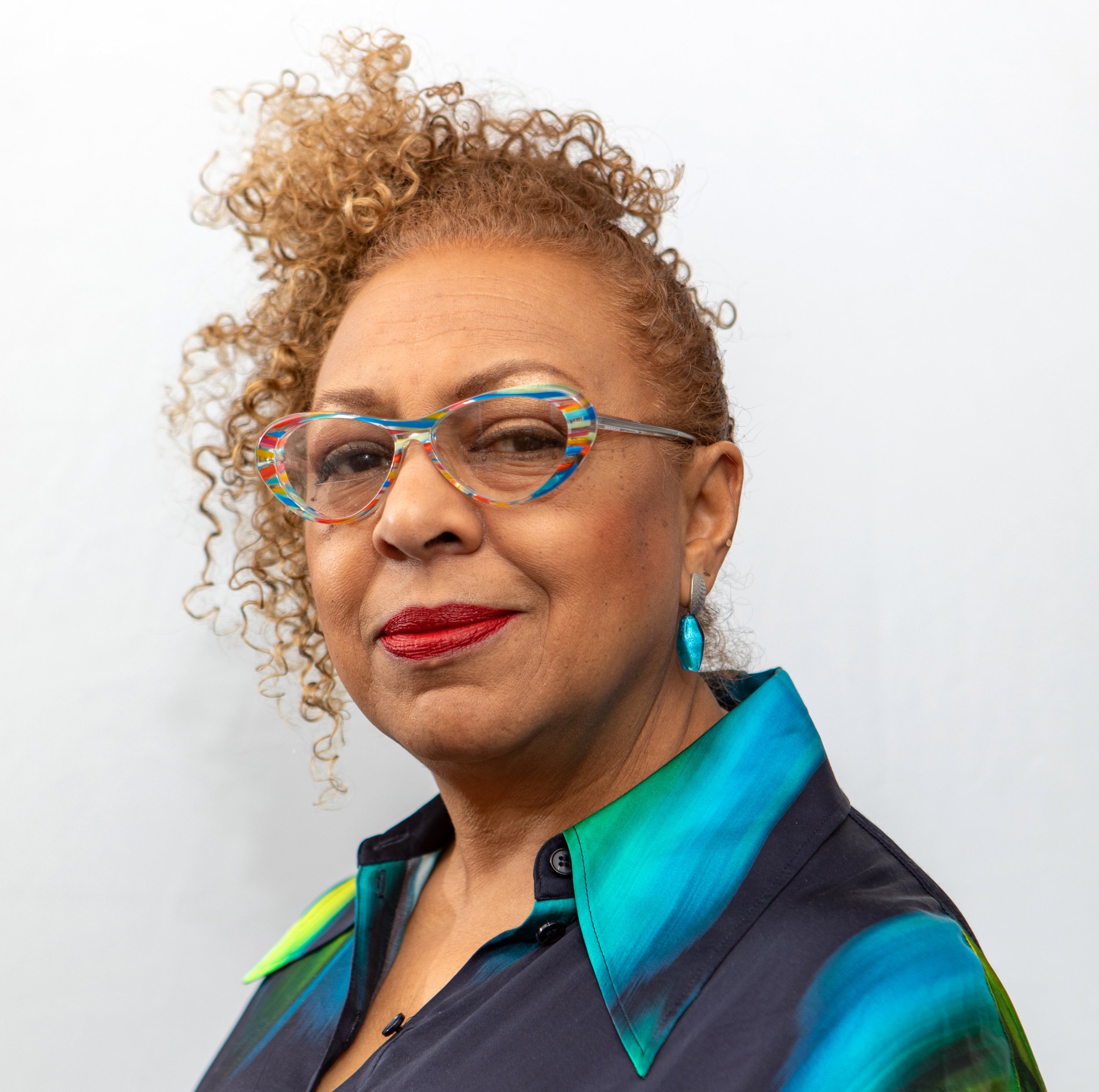 A headshot of a Black woman wearing glasses