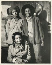 Black and white picture of three black women: Dindga McCannon (seated), Linda Hiwot (l.), and Miriam Francis (r.), Where We At Black Women Artists, circa 1975 (Photographer unknown). 